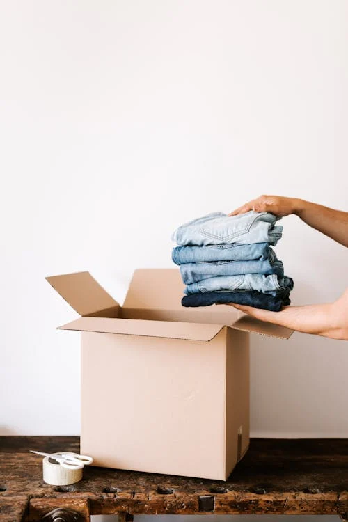 a person holding a stack of clothes